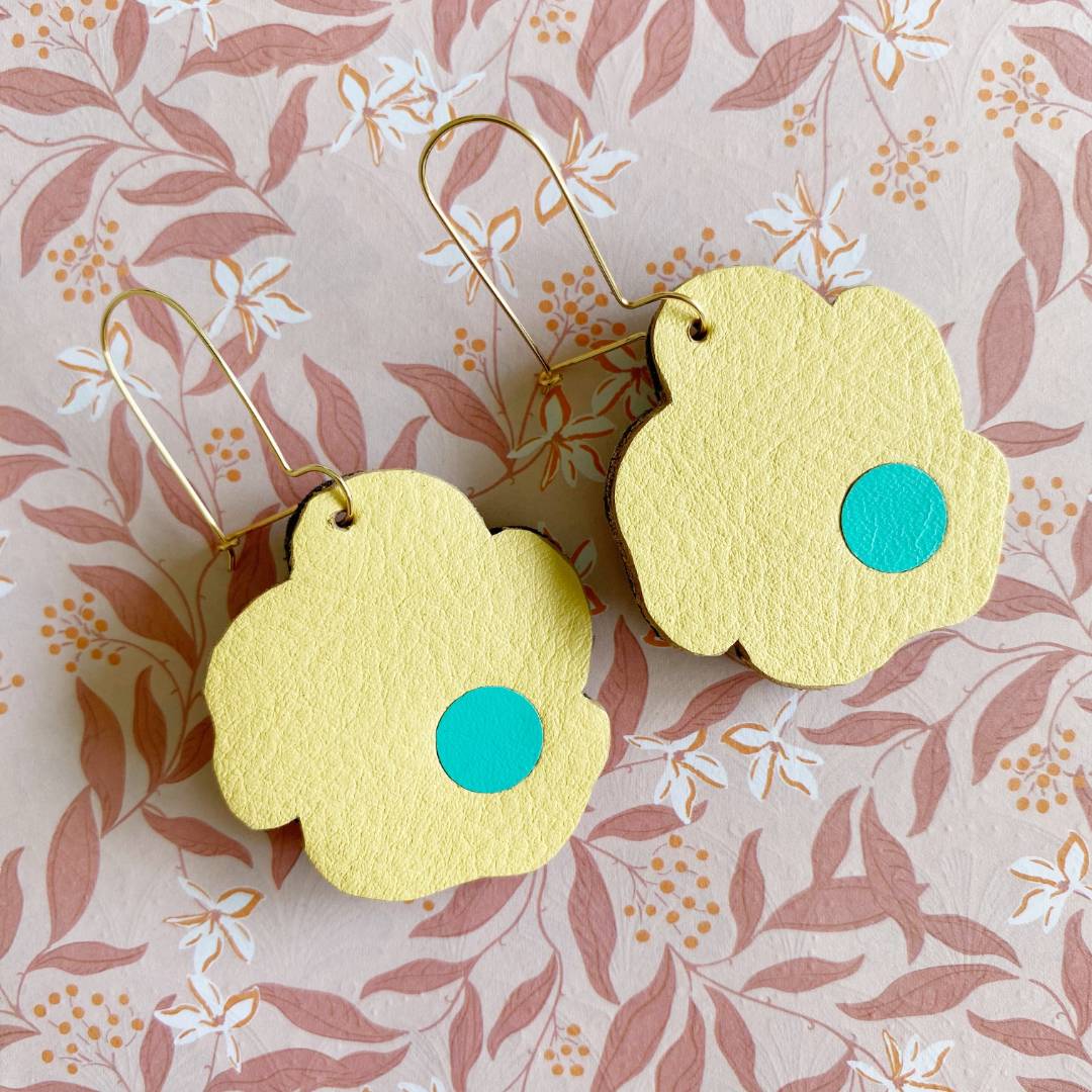 Aretes de cuero recuperado reversibles en forma de margarita. Diseño costarricense. Joyería artesanal contemporánea sostenible. Joyería de autor.