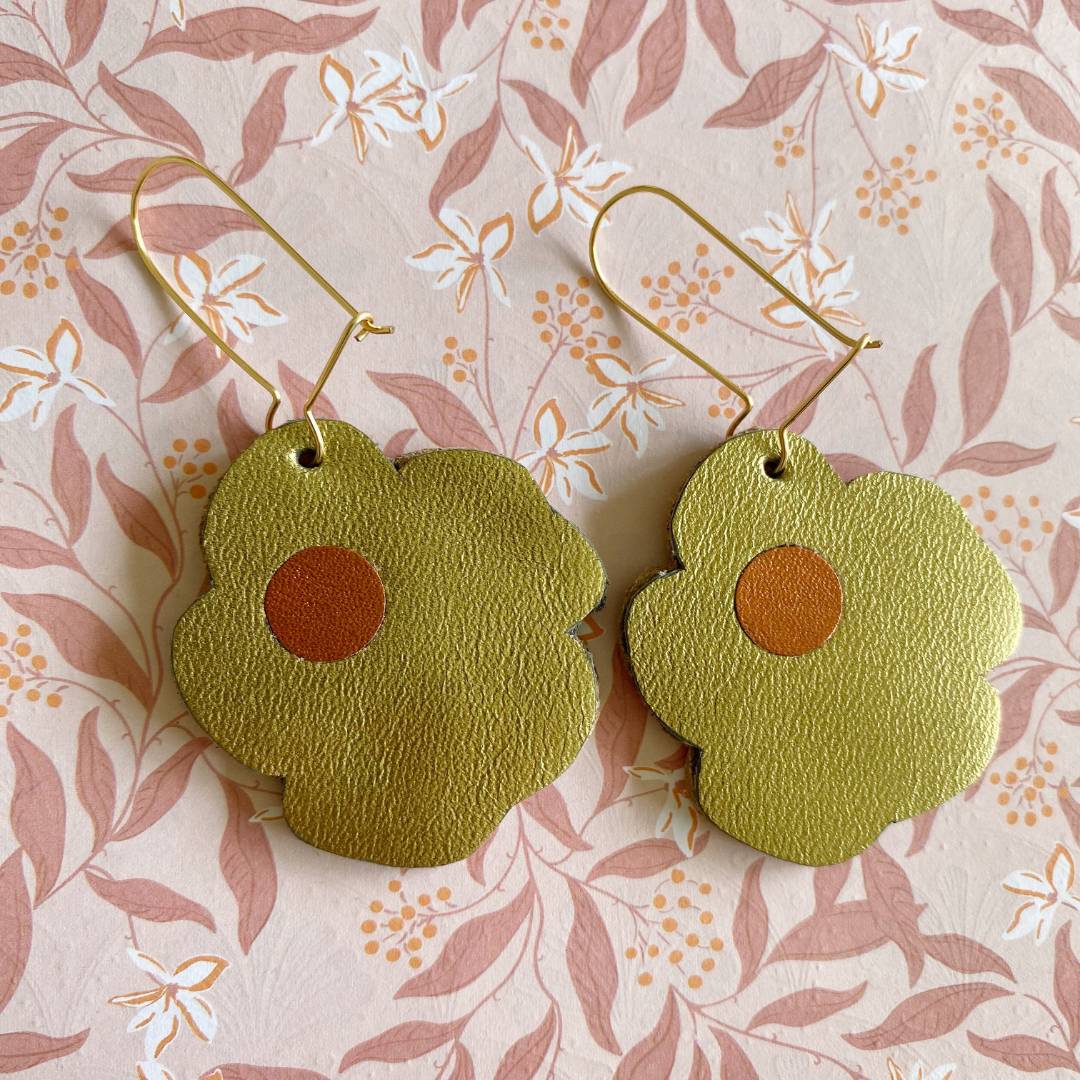 Aretes de cuero recuperado reversibles en forma de margarita. Diseño costarricense. Joyería artesanal contemporánea sostenible. Joyería de autor.