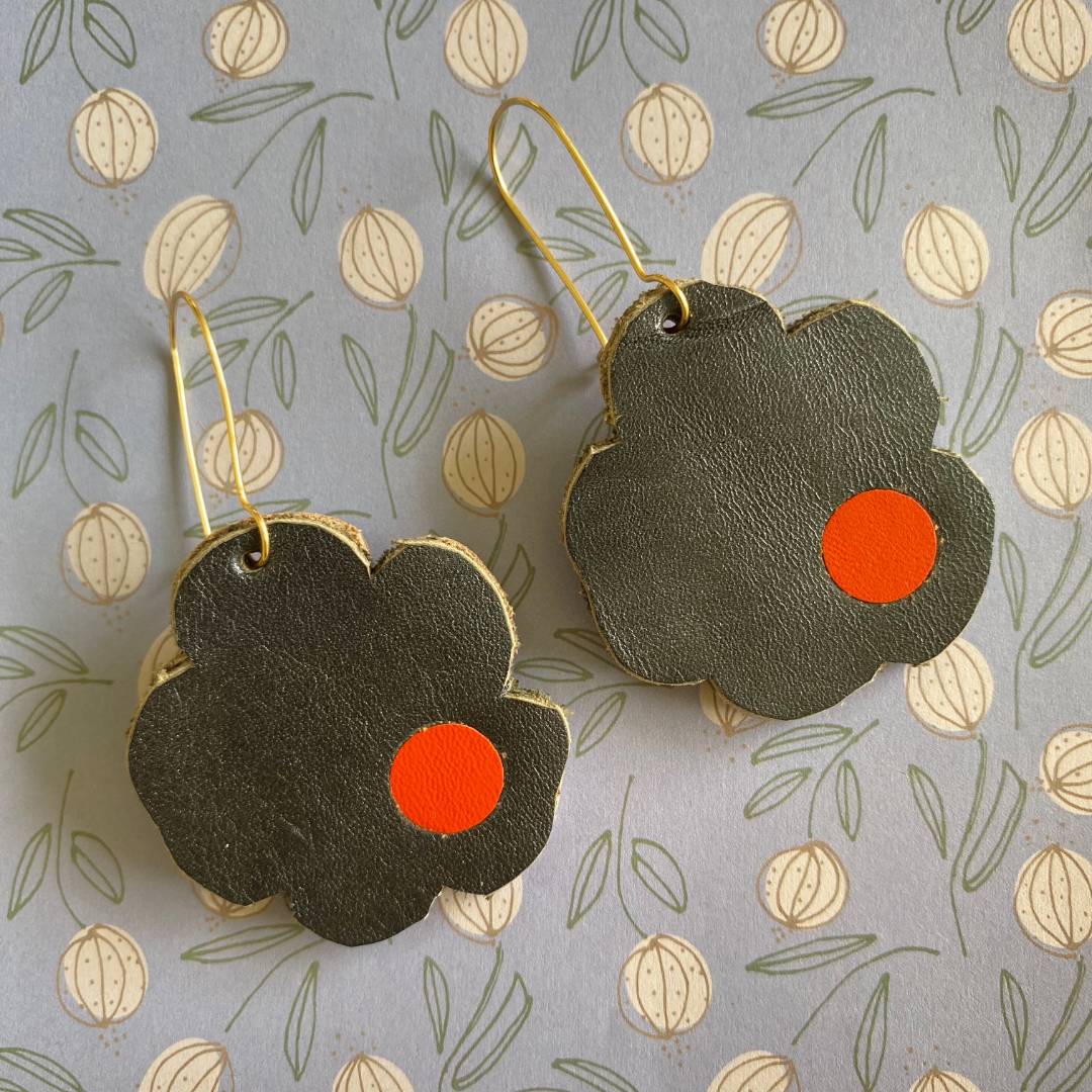Aretes de cuero recuperado reversibles en forma de margarita. Diseño costarricense. Joyería artesanal contemporánea sostenible. Joyería de autor.