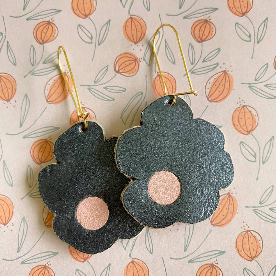 Aretes de cuero recuperado reversibles en forma de margarita. Diseño costarricense. Joyería artesanal contemporánea sostenible. Joyería de autor.