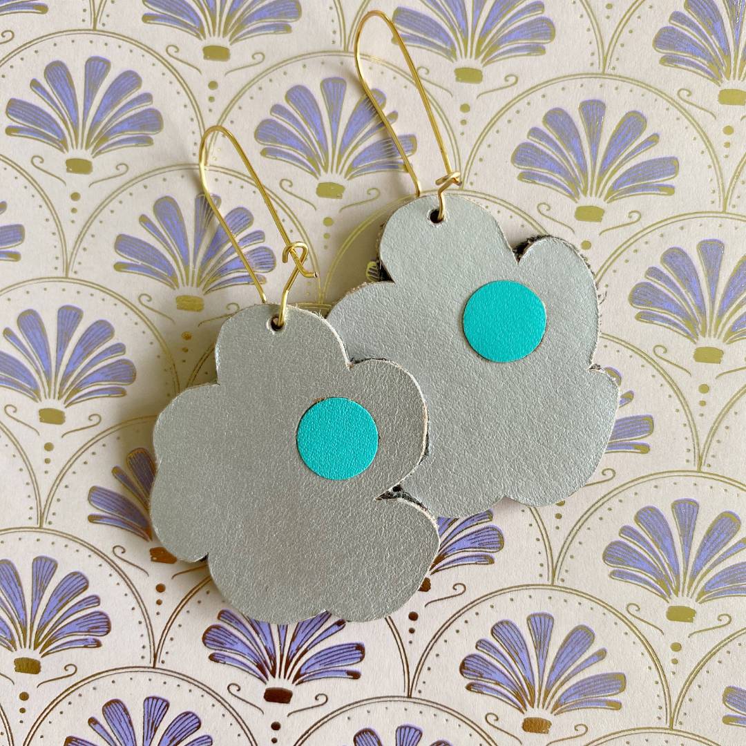 Aretes de cuero recuperado reversibles en forma de margarita. Diseño costarricense. Joyería artesanal contemporánea sostenible. Joyería de autor.