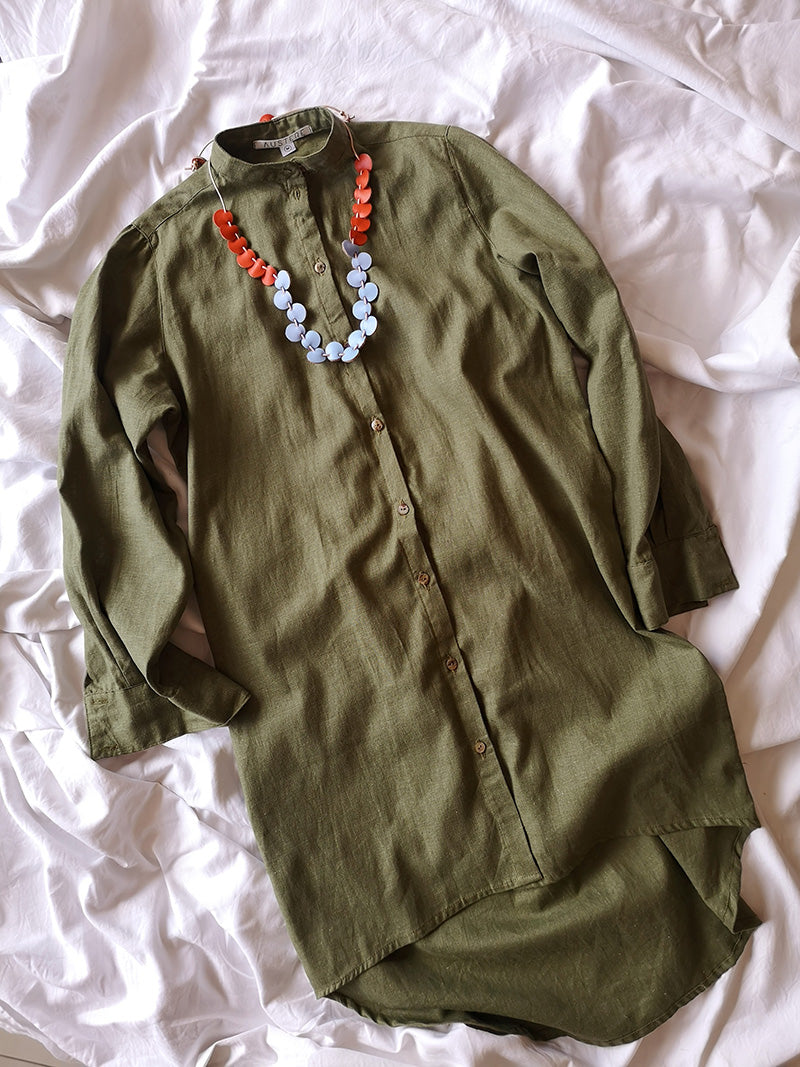 Collar Coral de cuero de color naranja y celeste sobre vestido verde musgo