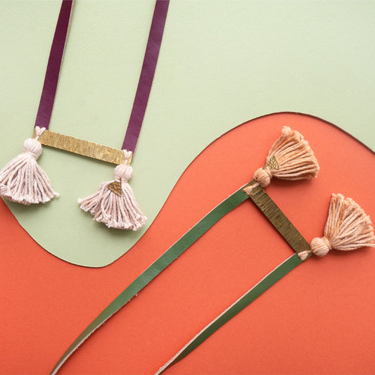 Juntos el collar versión vino con el collar versión verde olivo sobre fondo coral y verde claro