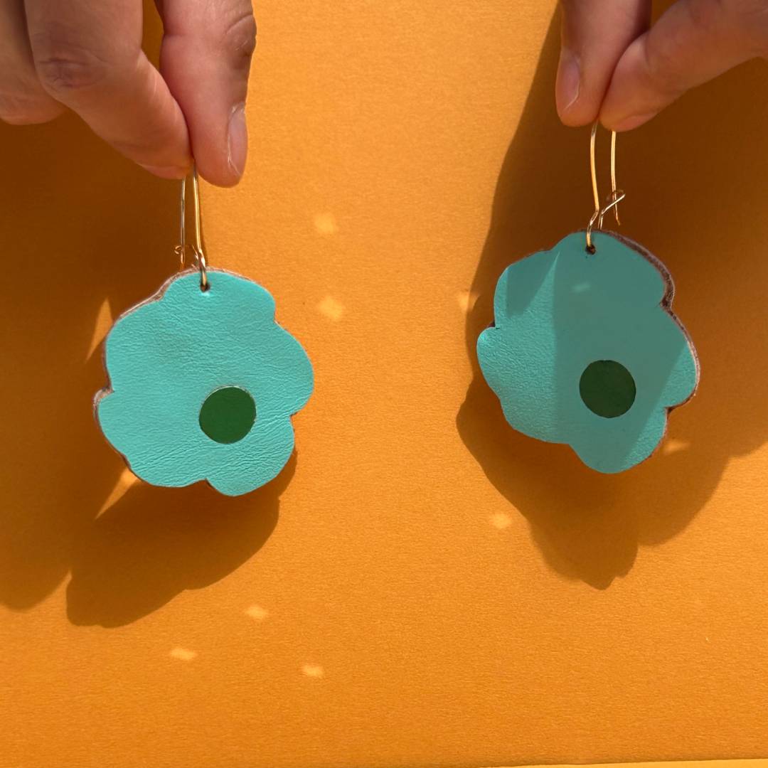 Aretes de cuero recuperado reversibles en forma de margarita. Diseño costarricense. Joyería artesanal contemporánea sostenible. Joyería de autor. 
