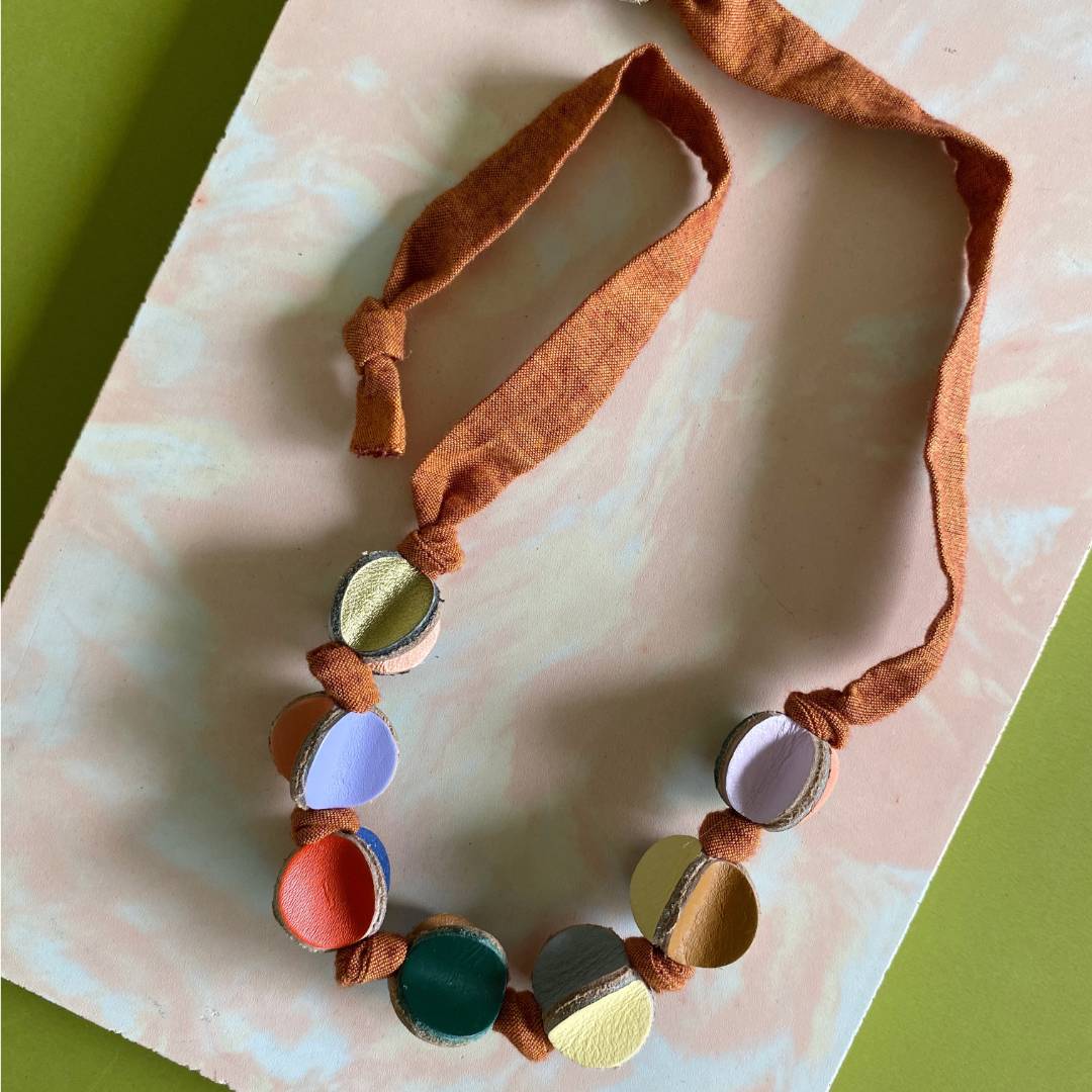 Collar ajustable de cuero recuperado de colores  y tela naranja  - diseño costarricense. Joyería contemporánea artesanal. 