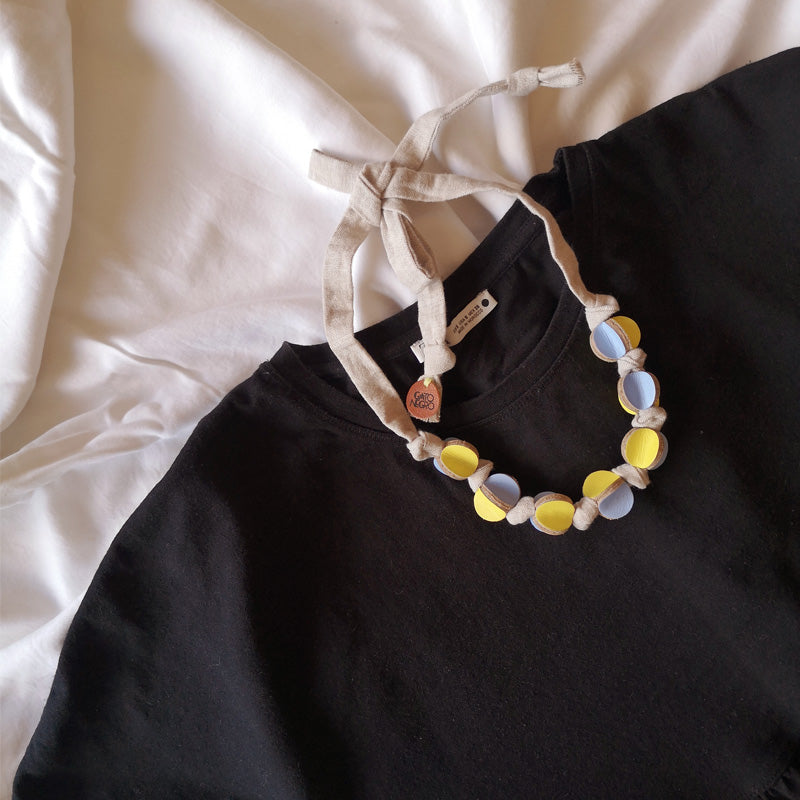 Collar cuero y tela amarillo y celeste sobre blusa negra - diseño costarricense