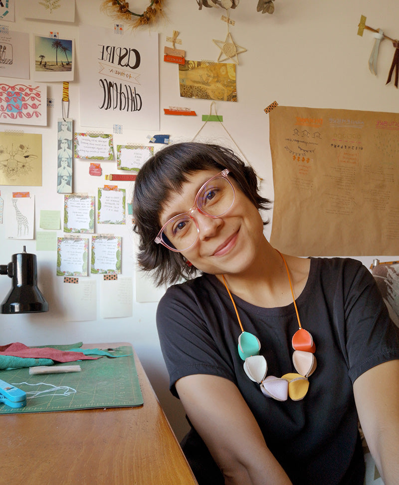Rebeca Zamora diseñadora de Gato Negro usando un collar Uchuva de cuero de diferentes colores combinados