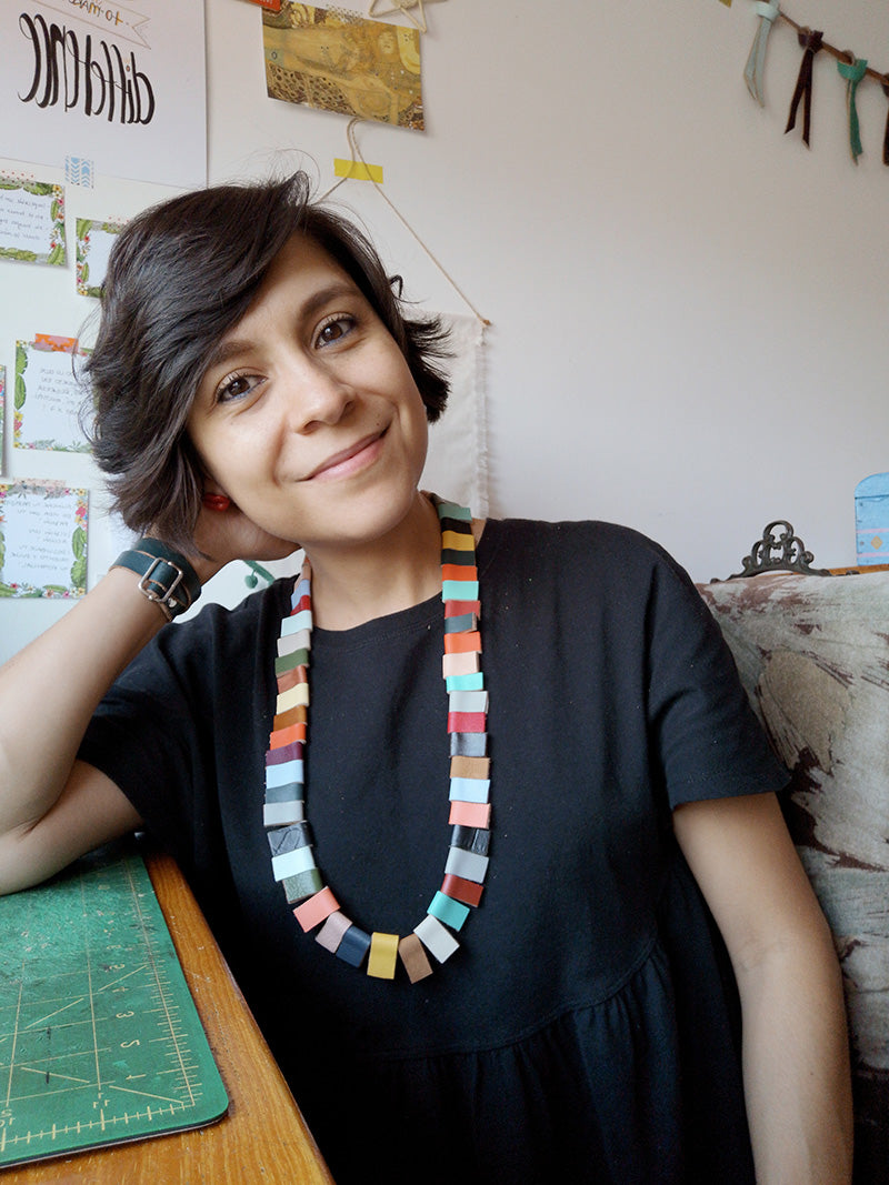 Rebeca Zamora diseñadora de Gato Negro usando el collar trópico de retazos de cuero de clolores
